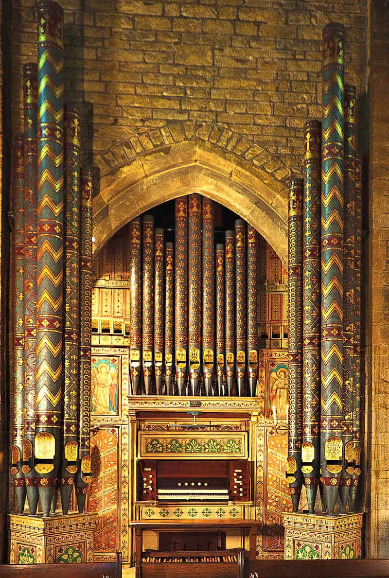 The painted Casson organ case at the west end of All Saints Church, with 16ft pipes in towers either side of the console